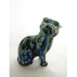 An early 19th century model of a seated cat with streaked and nottled blue, black and green glazed