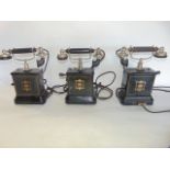 A trio of antique telephone units, each set within enamelled cases bearing marks Jydsk Telefon