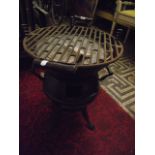 A small cast iron pot bellied barbeque raised on four swept supports, portable with side carrying