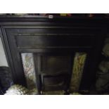 A late Victorian/Edwardian cast iron fire insert/surround incorporating two decorative ceramic