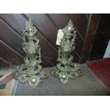 A pair of cast brass rococo chennets with scrolling acanthus and trailing floral detail