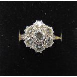 A diamond flower head cluster ring centred with a round brilliant-cut diamond weighing approximately