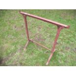 A pair of vintage iron work trestles with riveted detail together with one other