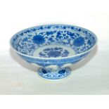 An oriental blue and white stemmed dish with trailing floral decoration and character mark to base