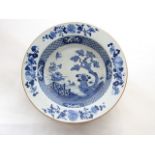 A late 18th century oriental basin, of shallow form, with blue and white painted decoration of a