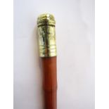 A bamboo walking cane terminating in an applied brass knop with screwing cap revealing a small