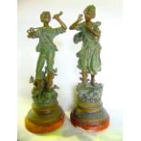 A pair of French painted spelter sculptural figures, one depicting a boy playing a horn, the other a