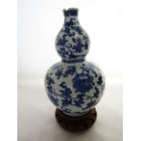 A 19th century oriental vase of double gourd shaped form, with blue and white painted trailing