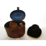 A late 19th century hat box of oval form with hinged lid and simulated painted grain finish to