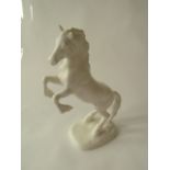 An unusual white matt glazed Beswick model of a rearing Welsh Cob raised on an oval base with