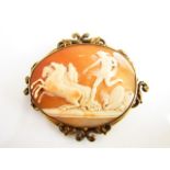 A large cameo brooch, carved relief of an angel with three rearing stallions, various armour on