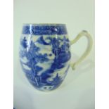 A 19th century oriental tankard of barrel shaped form with a blue and white painted pagoda and other