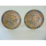 A pair of 19th century plates with painted and gilded Imari type decoration incorporating pagoda,