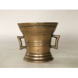 An antique cast bronze motar, with flared rim indistinct descriptive border and 'C' shaped