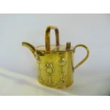 A 19th century brass watering can with hinged lid and embossed stylised foliate detail in the arts