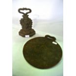 A 19th century cast iron door stop shoeing a shepherdess and an iron griddle