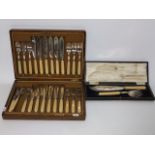 An oak cased set of twelve fish knives and forks with plated blades and polished composite