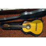 A cased acoustic guitar with label to sound hole interior Racardo Quiles Baloester