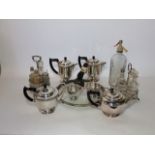 Assorted silver plated wares to include teapots, a circular tray raised on bun feet, two cruet