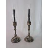 A decorative pair of 19th century silver plated candlesticks, with fruiting vine decorated stems and