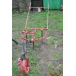 A Victorian single furrow three-bladed horse-drawn plough, the cast iron frame with D-shaped