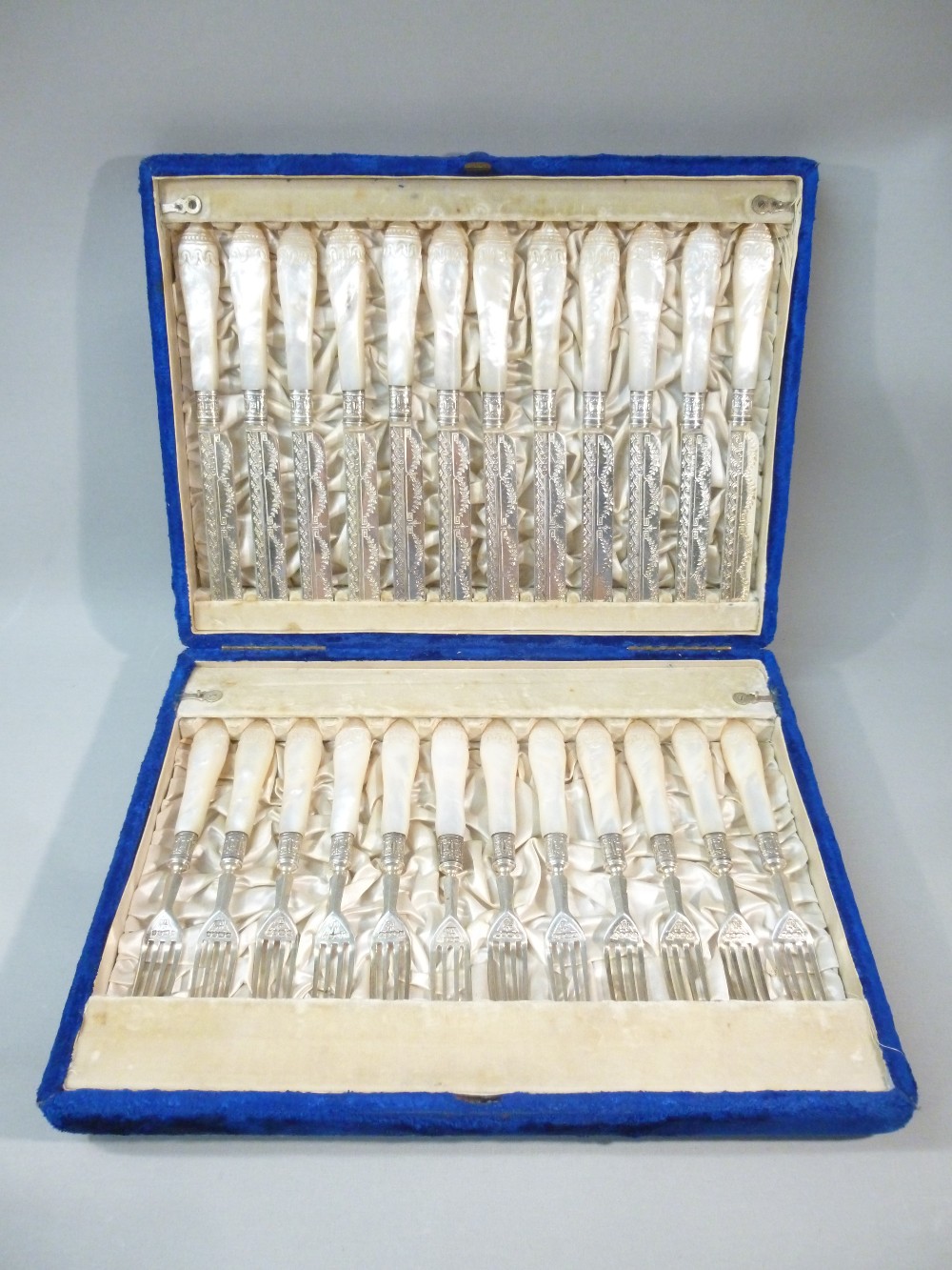 A TWELVE PLACE SETTING OF VICTORIAN DESSERT KNIVES AND FORKS, CHASED FLORAL DECORATION, HAND CARVED