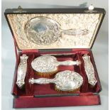 EDWARDIAN SILVER ART NOUVEAU DRESSING TABLE SET, THE FASCIAS STAMPED IN HIGH RELIEF, COMPRISING