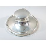 A PRESENTATION SILVER CAPSTAN INKWELL OF CIRCULAR FORM WITH HINGED LID REVEALING A GLASS LINER BY