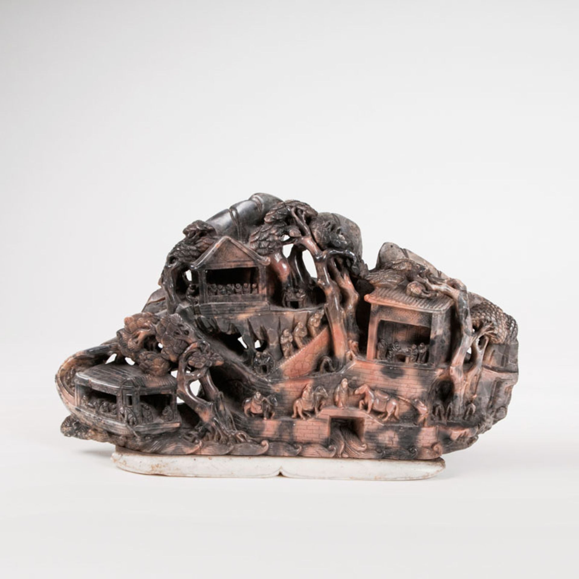 A soapstone carving depicting a mountainscape along the river with figures China, late Qing-