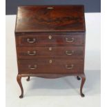 A GEORGE III MAHOGANY AND CROSSBANDED BUREAU the hinged rectangular top with an inlaid tooled