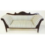 A REGENCY MAHOGANY SETTEE the curved and foliate-carved top rail above a padded back, padded sides