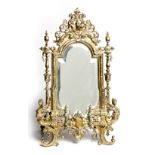 A VICTORIAN CAST-BRASS STANDING MIRROR the shaped and bevelled plate within an elaborately decorated