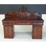 A VICTORIAN FLAME MAHOGANY PEDESTAL SIDEBOARD the rectangular top surmounted by a shaped, carved and