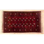 AN AFGHAN RUG, MODERN the red field with two rows of eight guls depicted in ivory, black and red