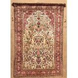 A SILK KESHAN PRAYER RUG, PERSIA, CIRCA 1940 the ivory mehrab with ascending flowering trees and