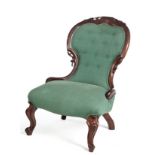 A VICTORIAN MAHOGANY GRANDMOTHER CHAIR the padded button-back within a conforming foliate-carved and