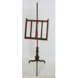 A VICTORIAN MAHOGANY ADJUSTABLE MUSIC STAND the slatted stand on a turned support, drum socle, on