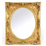 A GILTWOOD MIRROR, 19TH CENTURY the oval plate within a carved frame, acanthus-leaf cresting and