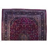A KESHAN CARPET, PERSIA, MODERN the burgundy-red field with a blue and beige floral medallion,