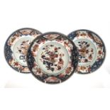 THREE CHINESE IMARI PLATES, 19th CENTURY each painted with a flower-filled jardinière beside a table