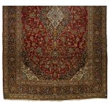 A KESHAN CARPET, PERSIA, MODERN the red field with a blue and ivory floral medallion and pendant,