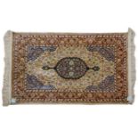 A HEREKE SILK RUG, TURKEY, MODERN the ivory field with a floral blue medallion, similar spandrel all