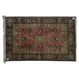 A QUM SILK RUG, PERSIA, MODERN the rose field with a small blue and gold floral medallion, all