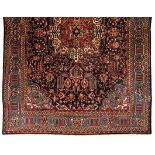 A MESHED CARPET, PERSIA, MODERN the dark blue field with an ivory floral medallion all with multi-