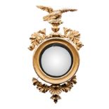 A REGENCY CONVEX GILT WOOD MIRROR the circular plate within a reeded slip and bead-mounted frame,