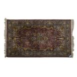 AN INDO PERSIAN RUG, MODERN the red field with a dark indigo-blue floral medallion, similar