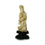 A SMALL CHINESE CARVED IVORY FIGURE OF GUANYIN NOT SUITABLE FOR EXPORT depicted standing, wearing