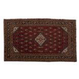 A CAUCASIAN RUG, ABERBIJAN, MODERN the red field with a stepped ivory medallion, similar spandrels