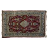 A QUM RUG, PERSIA, MODERN the red field with a blue and gold floral diamond medallion, similar