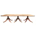 A REGENCY STYLE FLAME MAHOGANY EXTENDING DINING TABLE each D–end above a plain frieze, on a turned